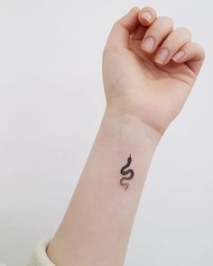 a woman's arm with a small tattoo on the left side of her wrist