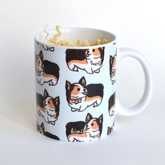 a coffee cup with corgi on it and gold sprinkles in the bottom