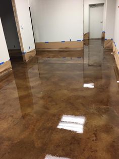 an empty room with white walls and brown flooring is being painted in the process of being polished