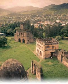 an old castle in the middle of a lush green field