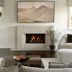 a living room filled with furniture and a fire place next to a painting on the wall