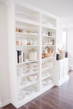 the shelves in this kitchen are filled with dishes