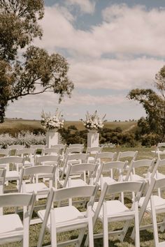 rows of white chairs sitting in the grass