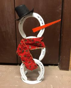 a snowman made out of horseshoes with a top hat and scarf on it