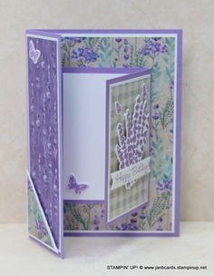 a handmade greeting card with purple flowers and butterflies on the inside, in front of a white background