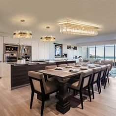 a dining room table with chairs and a chandelier hanging from it's ceiling