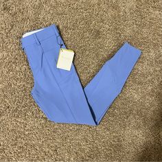 a pair of blue pants on the floor with a price tag attached to one leg