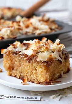 a piece of cake sitting on top of a white plate next to a skillet