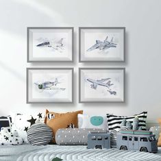 three framed pictures hang on the wall above a child's bed with toys in it