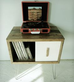 an old record player is sitting on top of a cabinet with some records in it