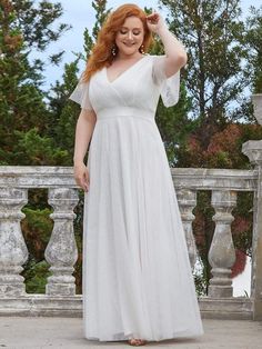 a woman in a white dress posing for the camera