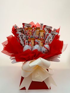 a bouquet of chocolates and candy wrapped in red paper