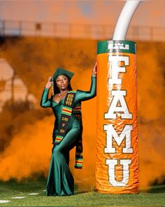 a woman in a green outfit is standing next to a sign that says team u