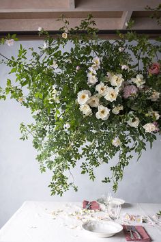 a vase filled with flowers sitting on top of a table next to plates and utensils