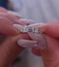 a woman holding a diamond ring in her hand