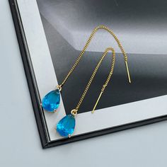 Dainty Blue Thread Earrings, Capri Blue Teardrop Earrings, Statement Blue Drop Earrings, Blue Wedding Earrings, Capri Blue Thread Earrings. These are simple and beautiful teardrop crystal earrings. Blue crystals are framed in bright gold and dangling from long thread. Measurements: The total length from the top of the hook to bottom - 3.74 inches (95 mm) approximately. Crystals: 12 mm x 8 mm The earrings would be a PERFECT GIFT for you and your family and friends! Click here to see more Modern E Blue Drop Crystal Earrings For Party, Single Blue Teardrop Earring, Blue Teardrop Dangle Earrings, Blue Teardrop Drop Earrings, Blue Drop Earrings With Ear Wire, Blue Long Drop Teardrop Earrings For Pierced Ears, Blue Long Drop Teardrop Earrings, Blue Long Drop Teardrop Earrings With Ear Wire, Blue Linear Earrings With Ear Wire For Gift