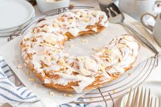 a frosted donut sitting on top of a cooling rack next to silverware