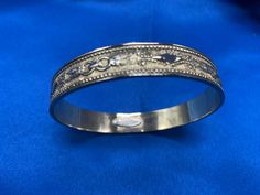 This is a vintage bangle in a gold finish from the famous Whiting & Davis Co. that started back in the late 1800's. This bangle as with most of their jewelry is made of gold-plated metal. It is truly costume jewelry but on the higher end. This type of jewelry started being made in the '50's and on.  The bangle has a a ring and feather design and it is a raised on the outside and smooth and shiny on the inside. There is a Whiting Davis in small raised metal on the inside of the bracelet as well. Ceremonial Etched Bangle, Adjustable Ornate Bangle For Formal Occasions, Victorian Cuff Bracelet Bangle For Ceremonial Occasions, Adjustable Engraved Victorian Bangle, Victorian Ceremonial Cuff Bracelet Bangle, Victorian Adjustable Engraved Bangle, Victorian Metal Cuff Bangle, Victorian Etched Round Bangle, Ceremonial Engraved Metal Bangle