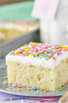 a piece of cake with white frosting and sprinkles