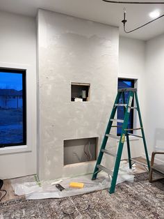 a ladder is in the middle of a room being remodeled with white walls and windows