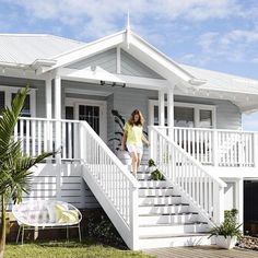 an image of a white house with stairs leading up to the front door and porch