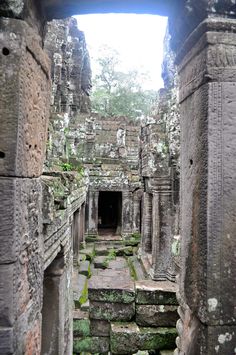 an ancient building that has been carved into the ground with moss growing on it's sides