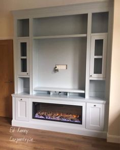 a white entertainment center with built in fireplace