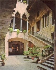 the entrance to a building with stairs and potted plants