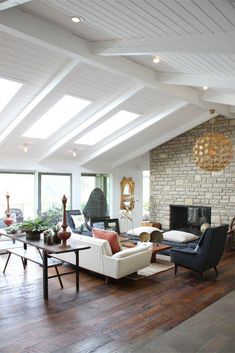 a living room filled with furniture and a fire place in the middle of an open floor plan