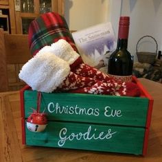 christmas eve goodies in a wooden crate on a table with wine bottle and socks