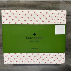 the box has hearts on it and says kate spade new york written in white ink