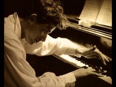 a man sitting at a piano with his hands on the keys