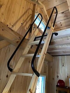 a ladder that is attached to the side of a wooden building with wood paneling