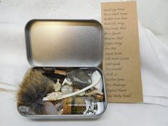 an open tin box with various items inside