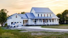 a white truck parked in front of a large house on the side of a road