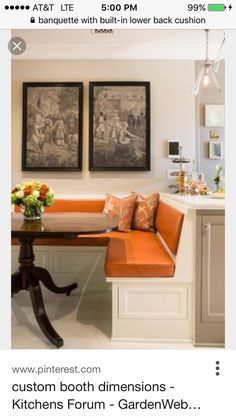 two framed pictures hang on the wall above a kitchen table with an orange bench in front of it