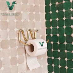 a roll of toilet paper is hanging on the wall next to a green tiled bathroom