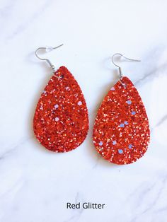 There is no easier way to take your look effortlessly into the new season than with these holiday drop glitter earrings. Perfect for celebrating the holidays and the upcoming New Year. Make a statement with these stylish and lightweight glitter earrings. Feature: Orange and USA earrings are size: 2.25" x 2" Gold, Red, Black, Purple, Blue, and Gold Star glitter earrings are size: 2.25" x 1.5" Usa Earrings, Easter Earrings, Side Design, Glitter Earrings, Boutique Homes, Gold Star, Red Glitter, Christmas Jewelry, Leather Earrings