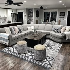 a living room filled with furniture on top of a hard wood floor covered in rugs