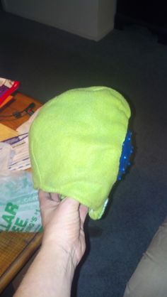 a person with a green hat on top of a wooden table in a living room