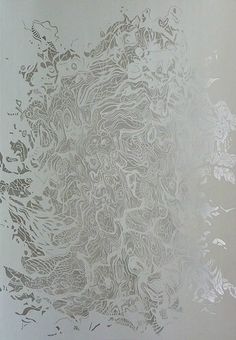 an abstract painting with white paint and silver foil on the wall in front of it