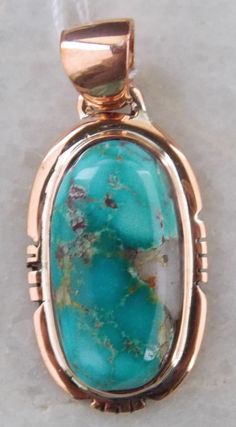 Hand Made Royston Turquoise - Copper Pendant 21644 Hand Made Royston Turquoise - Copper Pendant Belkis Minerals has been involved with jewelry since 2009 and is a leading seller of Bisbee turquoise jewelry in Bisbee. Our love for beautiful cabochons makes the pendant our primary focus. We sell our jewelry in Arizona and nearby, but now we will begin offering more to our ebay customers. This wonderful pendant features a Royston turquoise in a Southwest styled copper setting. The turquoise displays the classic characteristics of turquoise from Royston; blue green color accentuated by the rhyolitic matrix. This is a brand new pendant. The freeform oval turquoise is expertly cut with excellent shape, doming and luster. We can offer a copper chain if one is needed. Please consult us. Stone Orig Artisan Turquoise Jewelry With Polished Finish, Unique Turquoise Jewelry With Polished Finish, Untreated Chrysocolla Turquoise Jewelry, Oval Chrysocolla Jewelry With Patina, Collectible Round Turquoise Necklace, Artisan Turquoise Cabochon Jewelry, Oval Turquoise Necklace With Patina, Bisbee Turquoise, Artisan Jewelry Necklaces