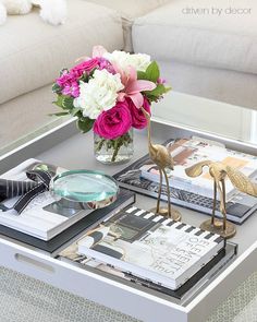 a coffee table with flowers and books on it