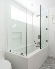 a white bathroom with a glass shower door