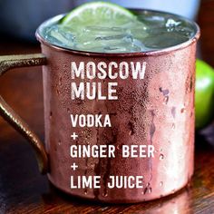 a moscow mule cocktail with ginger beer and lime juice in a copper mug on a wooden table