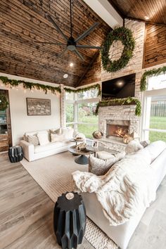 a living room with white couches and fireplace