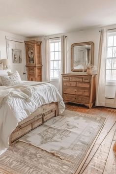 a bed sitting in a bedroom on top of a wooden floor next to two windows