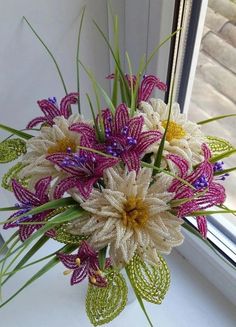 a bouquet of flowers sitting on top of a window sill