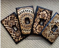 four decorative wooden switch plates sitting next to each other