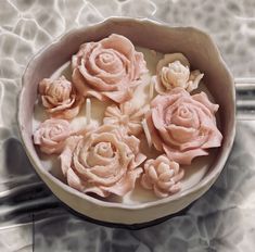 a bowl filled with pink flowers on top of a table